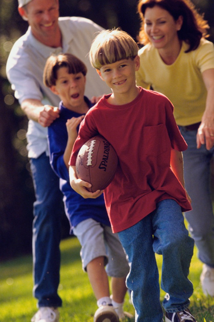 Two Foster Playing Football with Foster Parents